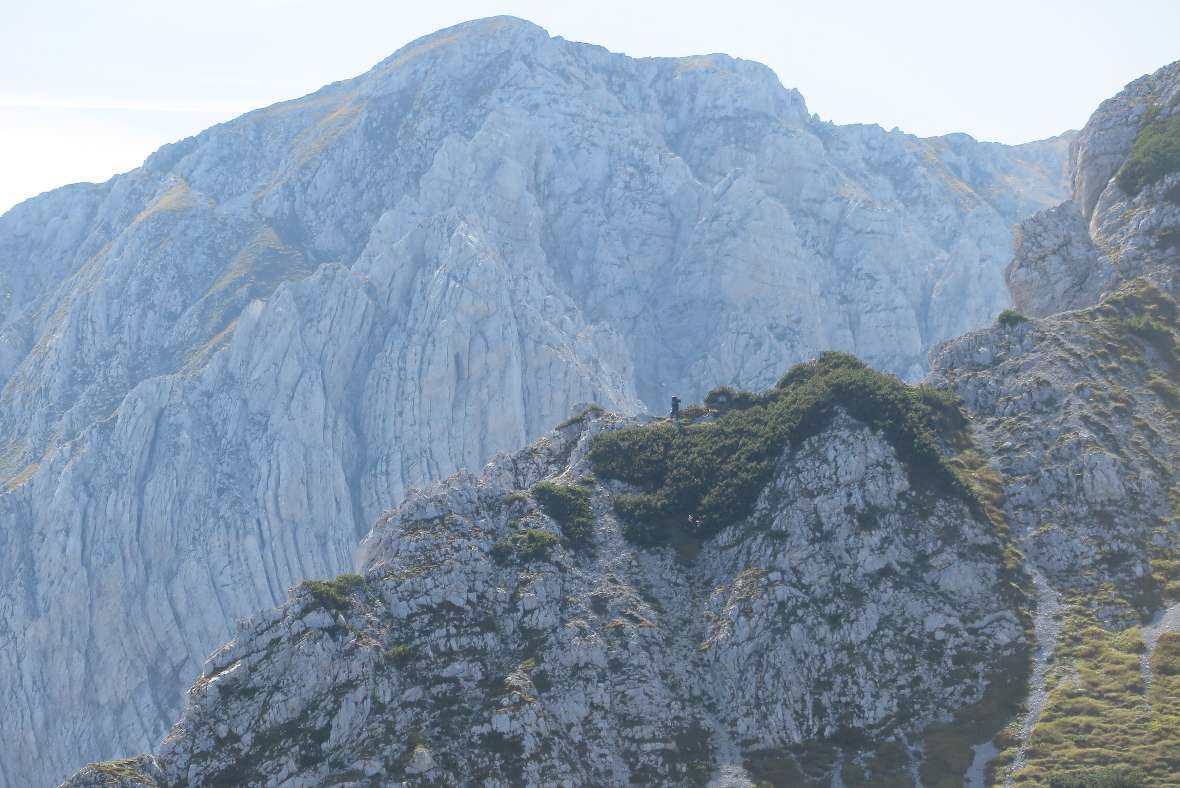 Auf einem Felsgrat im Hochgebirge geht ein Mensch