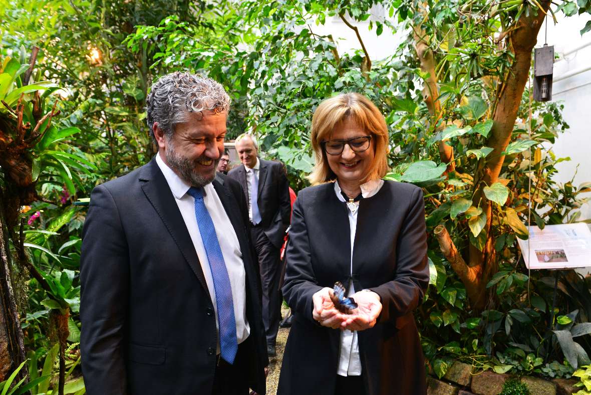 Zu sehen ist Frau Bundesministerin Maria Patek und Herr Burghauptmann Sahl. Frau Bundesministerin Patek hält einen blauen Schmetterling in beiden Händen
