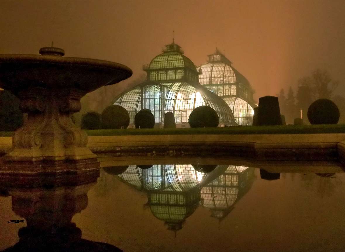 zu sehen ist ein großes Glashaus mit zwei Kuppeln bei Nacht