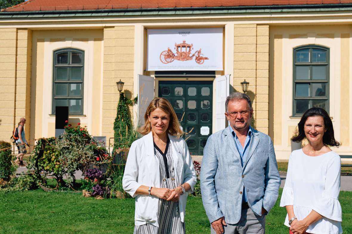 Frau Mag. Katrin Völk, Herr DI Andreas Fellner und Frau Dr. Monica Kurzel-Runtscheiner MAS vor der Wagenburg